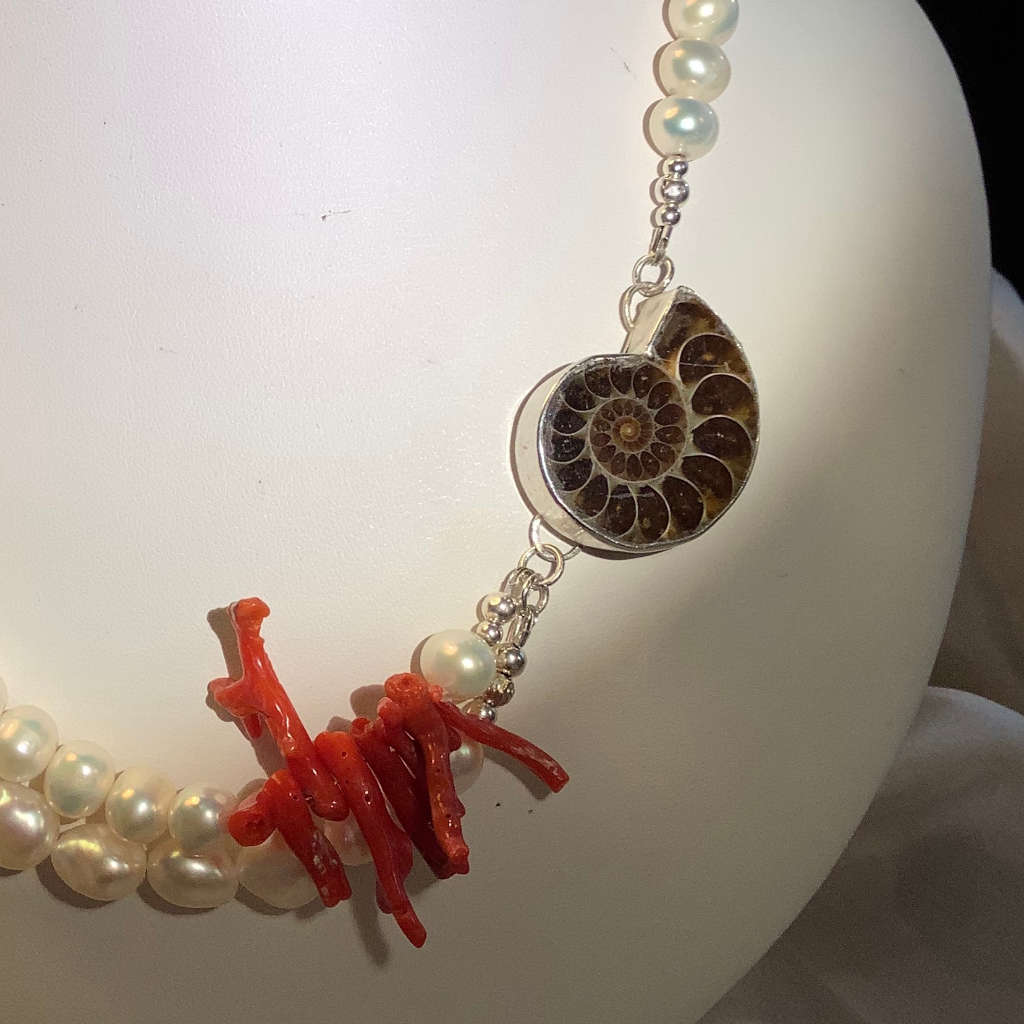 Statement necklace with an Ammonite set in a sterling silver bezel, natural coral and mixed size pearls